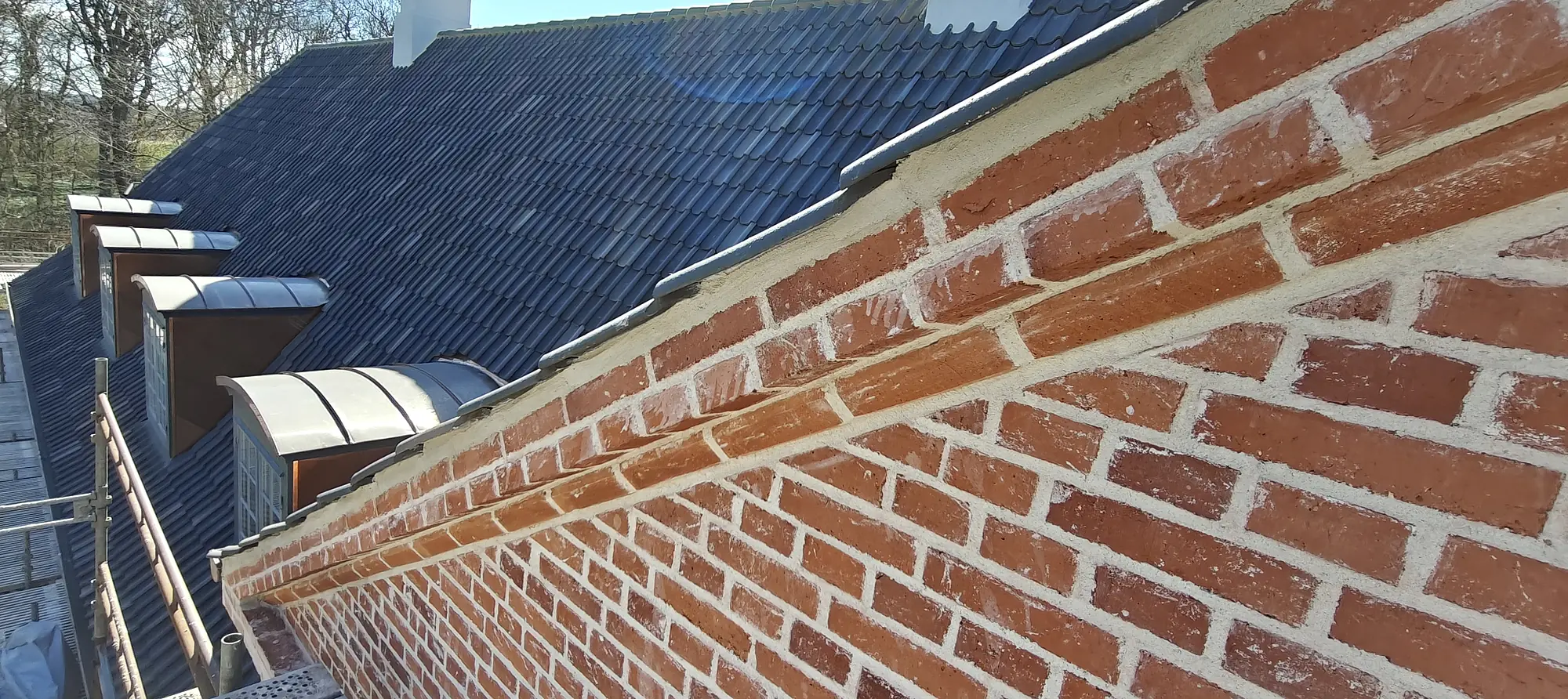 Restaureret murstensfacade og gesims ved tag